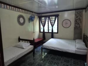 Naviti IslandWAI MAKARE HOMESTAY ROOM 2的带2扇窗户的客房内的2张床