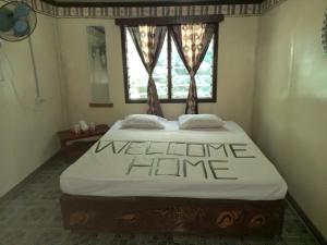 Naviti IslandWAI MAKARE HOMESTAY ROOM 2的一张位于房间的床,上面有迎宾家庭标志