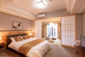 大阪川House道頓堀的一间卧室配有一张大床和电视