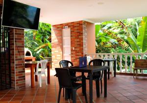 埃尔科莱希奥Finca Hotel Villa Gladys en Mesitas del Colegio的一个带桌椅和电视的庭院