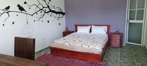 YaruguíQuinta Wiñay的卧室配有一张床,墙上挂着鸟笼