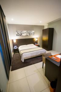 达喀尔利萨拉酒店的配有一张床和一张书桌的酒店客房