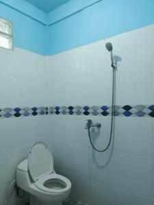 TelukdalemTOHO NIAS的浴室设有卫生间和蓝色灯光淋浴。