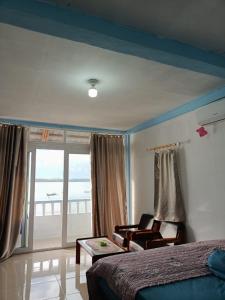 TelukdalemTOHO NIAS的卧室配有床、椅子和窗户。