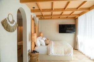 柴老海滩马尔代夫海滩度假酒店的卧室配有白色床和木制天花板