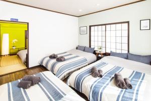 东京Vacation rental Miyabi/downtown/Tokyo airport的一间卧室配有三张床和毛巾