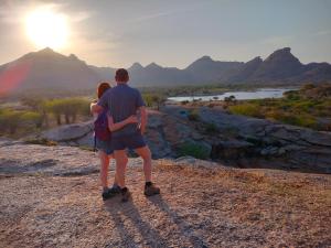 SheoganjJawai Bagpackers Hostel的站在山顶上看日落的男人和女人