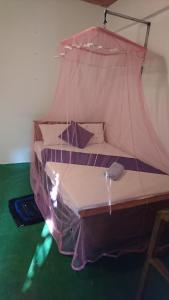 锡吉里亚Chandi Relax Hostel的一间卧室配有一张带蚊帐的床