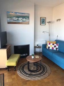 奥斯坦德Royal Zeezicht Oostende的客厅配有蓝色的沙发和桌子