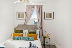 伦敦5 guests 3 beds 1 sofa bed Lewisham的一间卧室配有带橙色和绿色枕头的床
