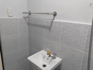 LocsinJLF Inn的浴室配有白色水槽和淋浴。