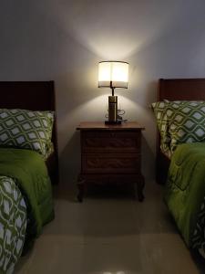 LocsinJLF Inn的一间卧室配有两张床和床头灯。