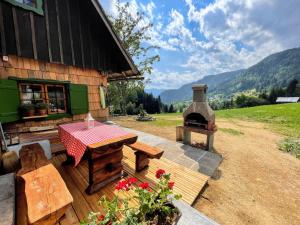博希尼Chalet Hike&Bike above Bohinj valley的一个带桌子和户外烤箱的庭院