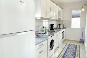 卡斯Ozy Apart Bayındır的厨房配有白色橱柜、洗衣机和烘干机