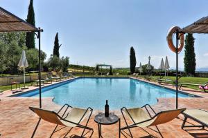 瓦里亚诺Via della Stella的一个带椅子和一瓶葡萄酒的游泳池