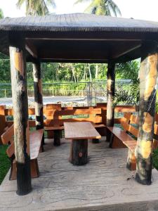 LocsinJLF Inn的公园内带长椅和桌子的木制凉亭