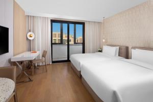 上海临港东缦国际公寓的酒店客房设有两张床、一张桌子和一台电视。