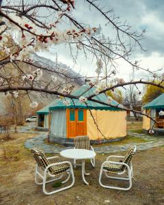 GulmitRoomy Yurts, Gulmit Hunza的一组椅子、一张桌子和一个帐篷