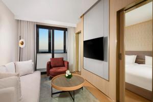 上海临港东缦国际公寓的酒店客房配有床、沙发和桌子。