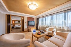 东莞东莞银城酒店的客厅配有沙发、椅子和电视