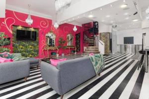 利物浦Luxury Mirror Party Pad with 4 Bedrooms! Silent Disco Package included的客厅设有两张沙发和粉红色的墙壁