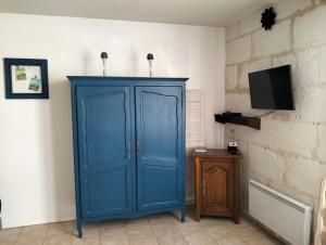 蒙特里夏尔Le Gîte des Marguerites的一间配有电视的蓝色橱柜