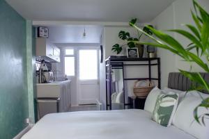 利特尔Annex By The Sea的一间带白色床的卧室和一间厨房