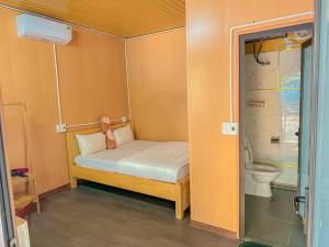 同文Plum Homestay的小房间设有一张小床和一个卫生间