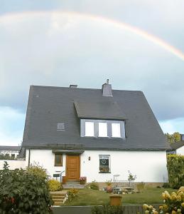 施马伦贝格Ferienwohnung Annes Stübchen的白色房子前面的彩虹