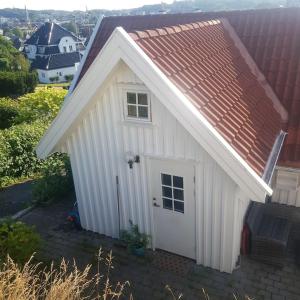 桑讷菲尤尔Lys og lettstelt leilighet med utsikt over byen的一间白色的小棚子,有红色的屋顶