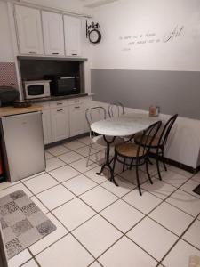 迪耶普le petit dieppois的铺有瓷砖地板,设有带桌椅的厨房。