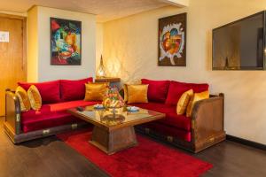 卡萨布兰卡乐尚尼枫Spa酒店的客厅配有红色的沙发和桌子