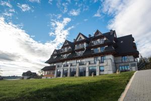 布科维纳-塔钱斯卡斯波尼克卡酒店的一座大建筑,位于青草山,天空蔚蓝