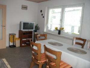 HambachFerienwohnung Fischer mit Balkon的客厅配有桌椅和电视。