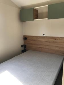 Bec-de-MortagneMobile-home Pin的小房间设有一张床和绿色橱柜
