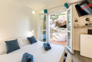 帕拉迪索海岸Villa Esmeralda - Free Wifi - with swimming pool的卧室配有白色的床和滑动玻璃门