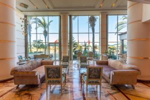 卡萨布兰卡乐尚尼枫Spa酒店的大堂配有沙发和椅子,并种植了棕榈树。