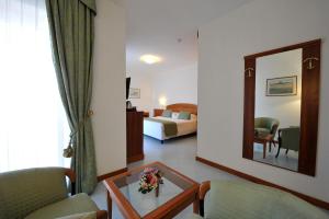 索伦托切萨雷奥古斯托大酒店的酒店客房,配有床和镜子
