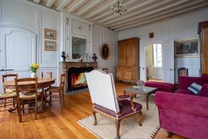勒芒Demeure Jousset des Berries的客厅配有紫色沙发和桌子