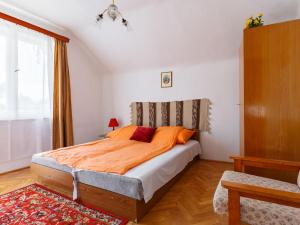 福纽德Holiday Home Iris by Interhome的一间卧室配有带橙色床单的床和窗户。