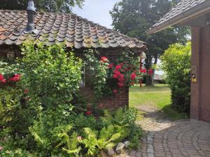 塞弗讷姆Bergerhof de Stal的砖砌建筑上一座花园,花园内有红玫瑰