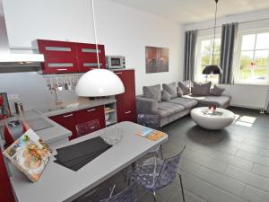 奥斯赛拜-塞林Villa "To Hus" F590 - Appartement 01 im EG mit Kamin und Terrasse的一间厨房和带红色橱柜的客厅