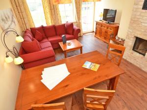 奥斯赛拜-塞林Villa "To Hus" in Sellin - WG 02 mit Kamin und Balkon的客厅配有红色的沙发和桌子