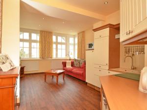 奥斯赛拜-塞林Villa "To Hus" F590 - Appartement 03 im ersten OG mit Balkon的厨房以及带红色沙发的起居室。