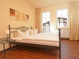 奥斯赛拜-塞林Villa "To Hus" F590 - Appartement 03 im ersten OG mit Balkon的一间卧室配有一张带白色床单的床和一扇窗户。