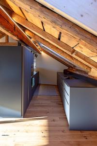 ObervazApartment Ferienhaus Tgioc by Interhome的阁楼间设有木制天花板和书桌。