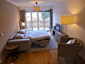 克莱恩 蒙塔纳Apartment Clavan by Interhome的一间卧室配有一张床、一张沙发和一把椅子