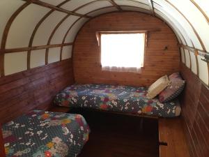 屈屈尼昂Le Camping de Cucugnan的小房间设有两张床和窗户