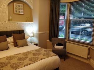 鲍内斯温德米尔墨尔本宾馆的一间卧室设有一张床、一个窗口和一把椅子