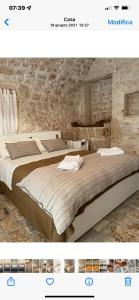 莫诺波利Masseria I Raffi b&b的一间卧室设有两张床和石墙